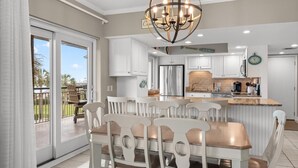 A modern kitchen with white cabinetry, a central island, and a chandelier. - 3rd Flr, 3 Bdrm Oceanview Condo Beach Oasis (Pawleys Island)