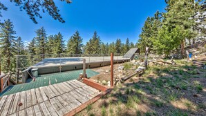 A wooden deck with a green roof, surrounded by trees and a rocky landscape. - Zephyr Cove Studio Unit 6 (Zephyr Cove)