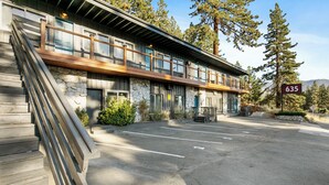 A modern building with a stone facade, a wooden deck, and a parking lot. - Zephyr Cove Studio Unit 6 (Zephyr Cove)