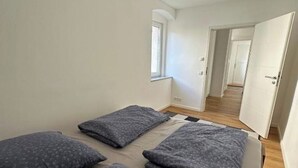A room with a bed, pillows, a window, and a door leading to another room. - Spacious vacation apartment in Dresden Neustadt - your stylish temporary home (Dresden)