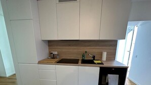 A modern kitchen with white cabinetry, a wooden countertop, and a built-in dishwasher. - Spacious vacation apartment in Dresden Neustadt - your stylish temporary home (Dresden)