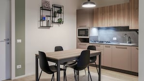 A modern kitchen with wooden cabinets, a built-in microwave, and a gas stove. - Attilia House - with WiFi and air conditioning (Sirmione)