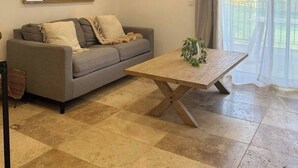 A living room with a grey sofa, a wooden coffee table, and decorative wall art.