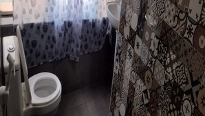 Ein Badezimmer mit Toilette, Waschbecken und einer duschgemusterten Vorhang.
