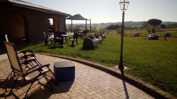 A patio area with outdoor seating, a pergola, and a view of the countryside.