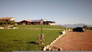 A house with a sloped roof, a paved driveway, and a car parked on the side.