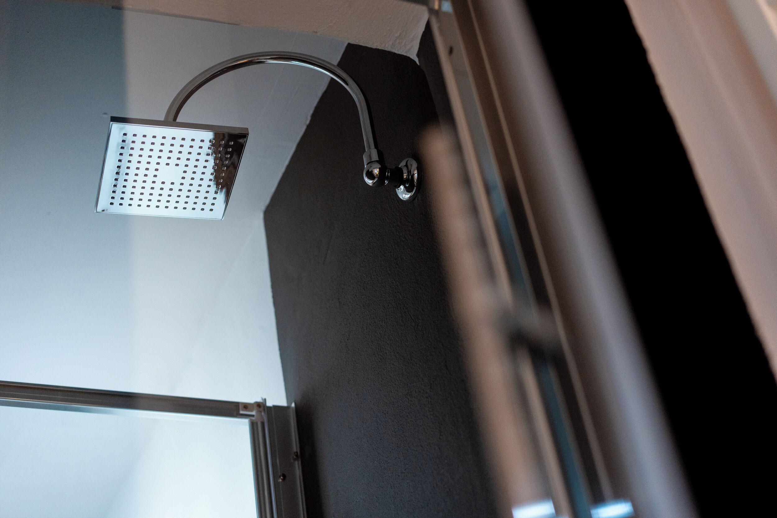 A showerhead mounted on a wall with a chrome finish.