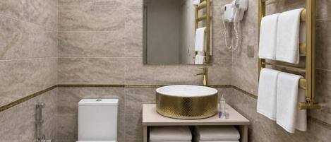 A modern bathroom with a toilet, sink, and shower.