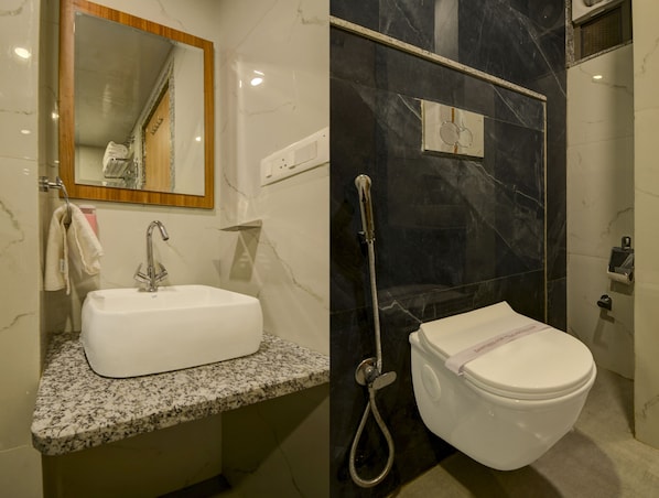 A bathroom with a white sink, a mirror, a shower, and a toilet. - Hotel ParkView Inn (Udaipur)