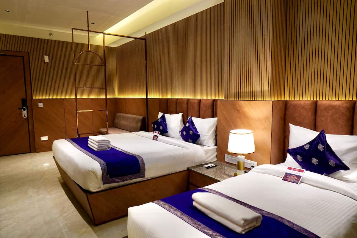 A hotel room with two beds, wooden paneling, and a modern design.