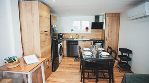 Una cocina compacta con armarios de madera, lavavajillas, un lavabo y una ventana sobre la encimera.