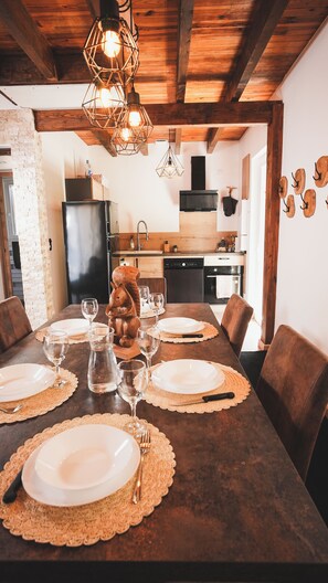 Un comedor con una mesa de madera dispuesta para cuatro personas, rodeada de sillas.