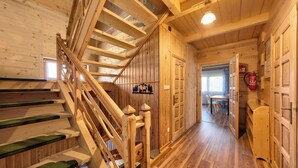 Eine Holztreppe mit grünen Teppichstufen, die zu einer oberen Etage führt.