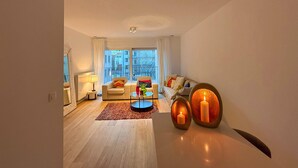 A modern living room with a sofa, armchairs, a coffee table, and a view of the city through large windows. - Apartment in Brussels Near European Parliament (Brussels)