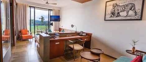 Ein modernes Hotelzimmer mit großem Fenster, Schreibtisch, Sofa und einem Tigergemälde.