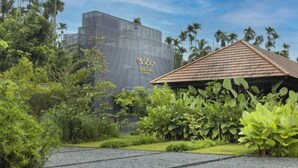 A modern building with a distinctive geometric facade and a tropical garden setting. - Saptha Resort and spa (Sulthan Bathery)