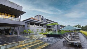 A modern hotel with a rooftop pool area, outdoor seating, and a covered patio. - Saptha Resort and spa (Sulthan Bathery)