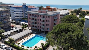 A multi-story hotel with a rooftop pool, a beach view, and a parking area. - Contemporary apartment in the heart of Lido del Sole (San Michele Al Tagliamento)