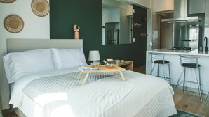 A modern hotel room with a large bed, a small kitchenette, and a breakfast tray on the bed. - Chic Loft w/ AC, Walkable Area (Cuauhtémoc)