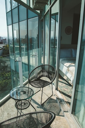 Enjoy a city view from the comfort of your balcony with a glass door leading to a cozy bedroom.