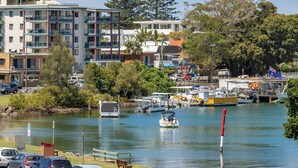 A marina with boats, a flag, and a building with balconies. - The Marina 308 - central Forster (Forster)