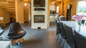 A modern interior with a fireplace, dining area, and kitchen. - Nice apartment in villa for 8 guests with WIFI, pool, TV and terrace (Annaberg Im Lammertal)