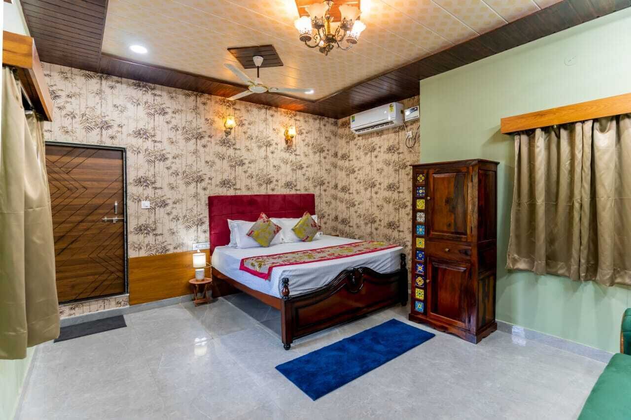 Une chambre à coucher comprenant un lit, une armoire, un ventilateur de plafond et une table de chevet.