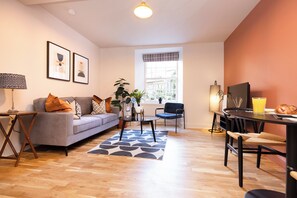 Familienapartment, Stadtblick | Wohnbereich | LED-Fernseher