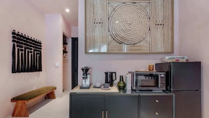 Une cuisine moderne équipée d’une machine à café, d’un four à micro-ondes et d’un réfrigérateur.