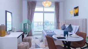 Een moderne hotelkamer met een groot bed, een eettafel en uitzicht op de stad.