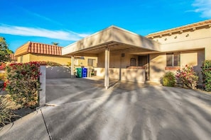 A modern two-story house with a covered patio, a garage, and a well-maintained garden. - Fairway Retreat | 2BR Resorter (Palm Desert)