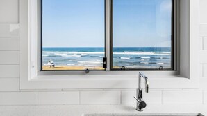 A bathroom with a large window overlooking the ocean, a sink, and a faucet. - Absolute Beachfront Apartment 4T (Lennox Head)