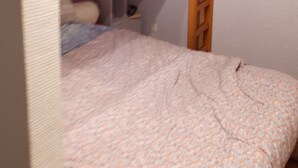 Una camera con un letto a castello, una scala, un comodino con una lampada e un piccolo ripiano.