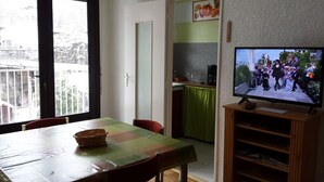 Zona pranzo con tavolo, sedie e televisore.
