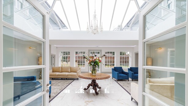 A spacious, well-lit room with a high ceiling, a central round table, and seating arrangements. - Luxury 7-Bed Villa w/ Gym, Outdoor Sauna, WiFi & Nicklaus Golf at Mount Juliet (Mount Juliet)
