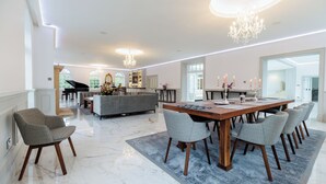 A spacious dining area with a marble floor, a wooden dining table, and grey upholstered chairs. - Luxury 7-Bed Villa w/ Gym, Outdoor Sauna, WiFi & Nicklaus Golf at Mount Juliet (Mount Juliet)