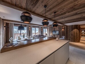 Enjoy meals and entertainment in this well-appointed kitchen and dining area with a central island, dining table, and flat-screen TV.
