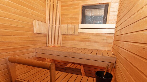 A sauna with wooden benches, a window, and a bucket. - Petsukka by Interhome (Kittilä)