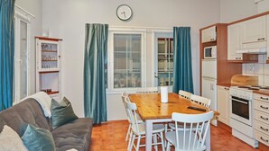 Un espacio habitable compacto con comedor, kitchenette y sofá.
