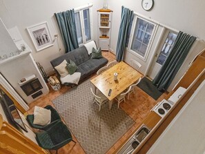 A compact living space with a sofa, dining table, and kitchenette.