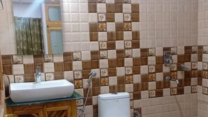 A bathroom with a sink, toilet, and shower. - Hotel Ldumra Oasis (Leh)