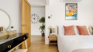 Ein Schlafzimmer mit Bett, Nachttisch, Lampe und einem Poster an der Wand.