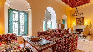 A traditional interior with a sofa set, a fireplace, and a chandelier. - Dar Salam, swimming pool, rooftop, staff, Medina (Marrakech)