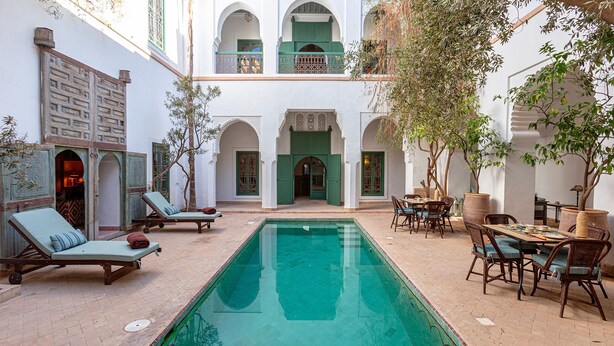 A courtyard with a swimming pool, lounge chairs, and outdoor seating. - Dar Salam, swimming pool, rooftop, staff, Medina (Marrakech)