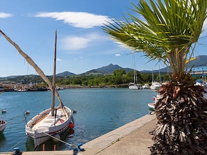 A marina with boats docked, a palm tree, and a mountainous landscape in the background. - Air-conditioned T2 with garden near central beach (Argelès-sur-Mer)