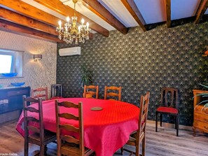 Enjoy meals in this cozy dining area with a round table, wooden chairs, and a chandelier.