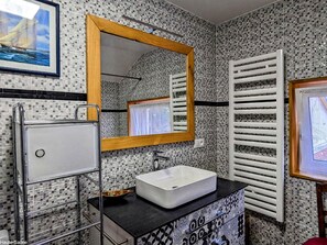 Bathroom features a modern sink, mirror, and mosaic tile walls.