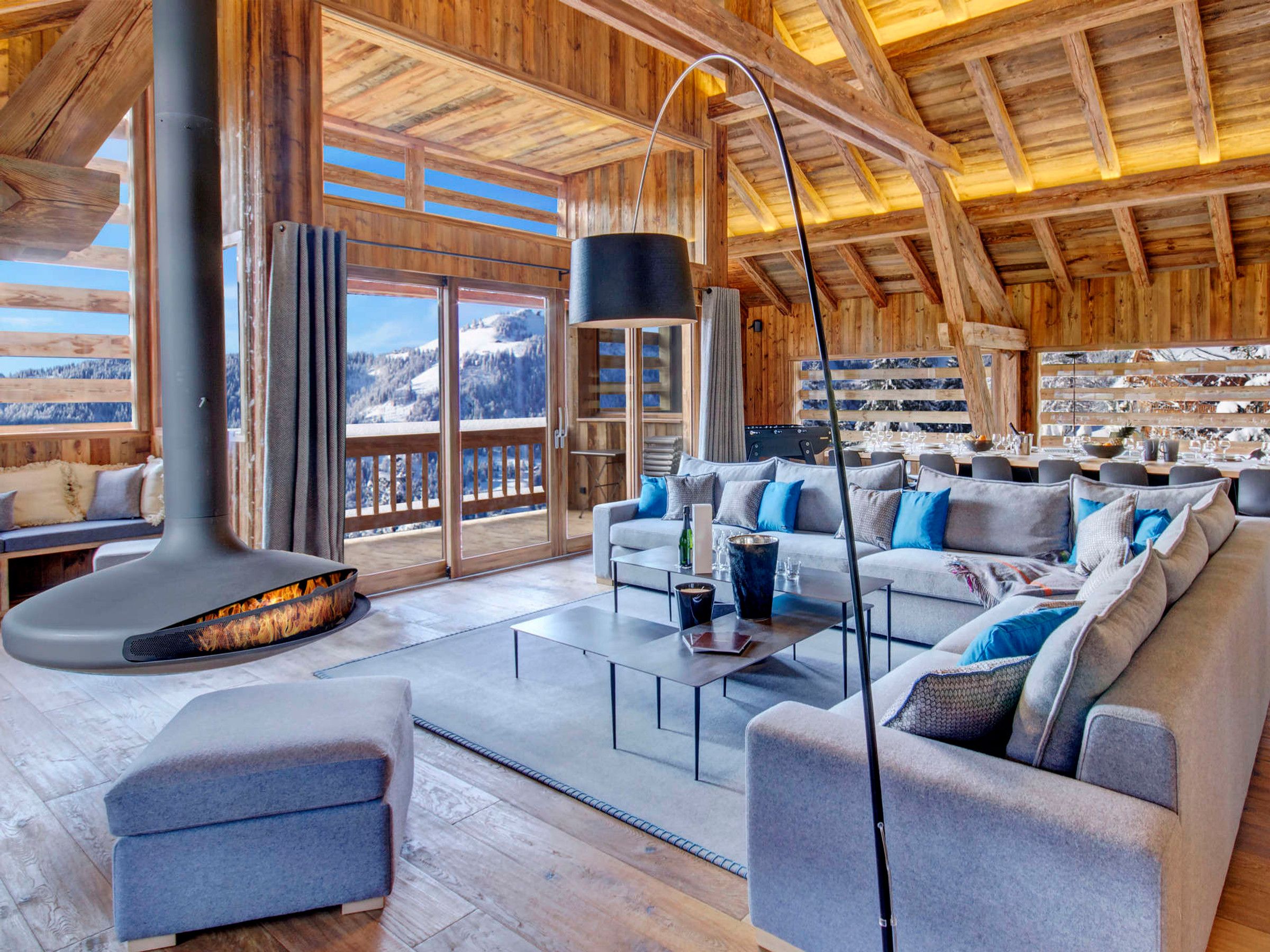 A spacious living area with a large fireplace, a sofa set, and a dining table.