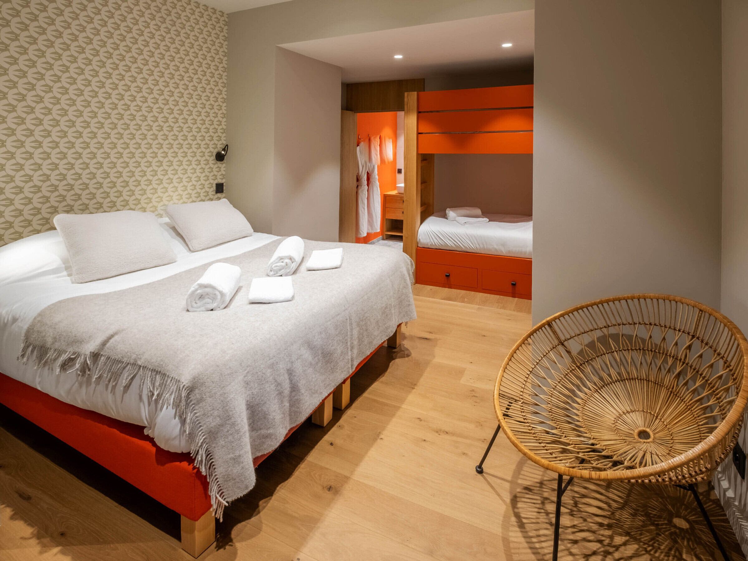 A hotel room with a bed, a chair, and a wardrobe.