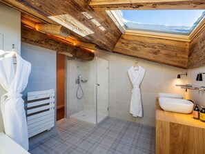 Bathroom features a walk-in shower, bathtub, and vanity with a large sink.